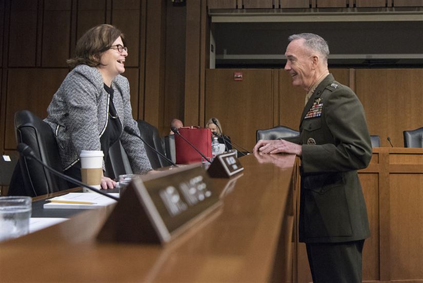 A photo of a forensic psychologist meeting with an army general in a courtroom.